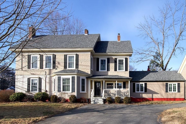 view of front of property featuring covered porch, a shingled roof, and a chimney