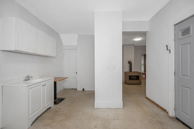 interior space with light floors, a sink, and baseboards