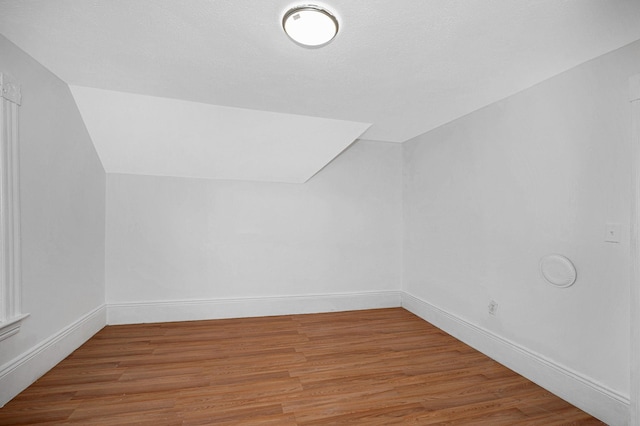 bonus room featuring lofted ceiling, wood finished floors, and baseboards