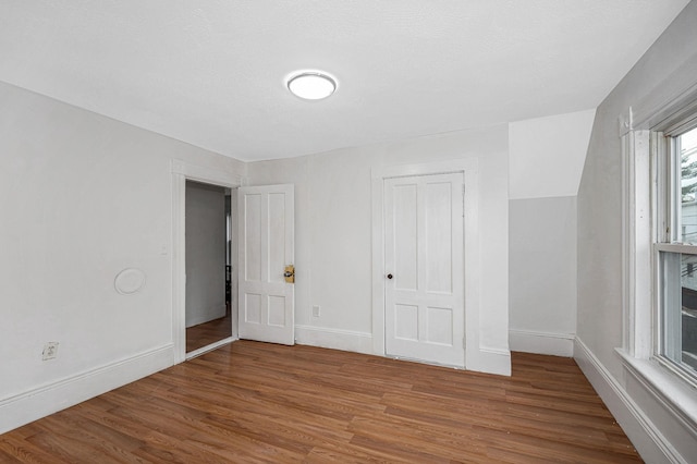 unfurnished bedroom with a closet, baseboards, and wood finished floors