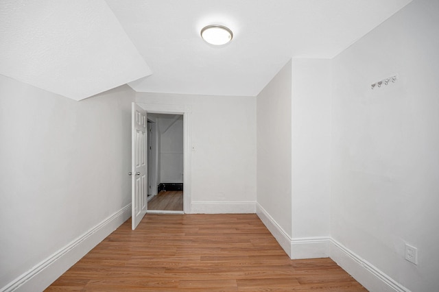 additional living space with light wood finished floors and baseboards