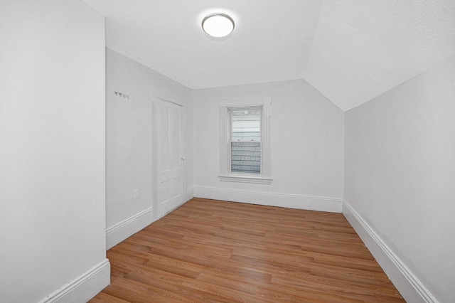 bonus room featuring lofted ceiling, baseboards, and wood finished floors