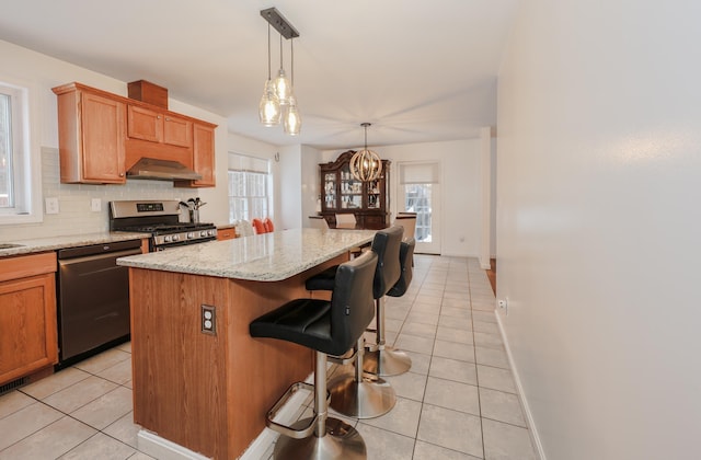 kitchen featuring stainless steel range with gas cooktop, a center island, light tile patterned floors, decorative backsplash, and dishwashing machine