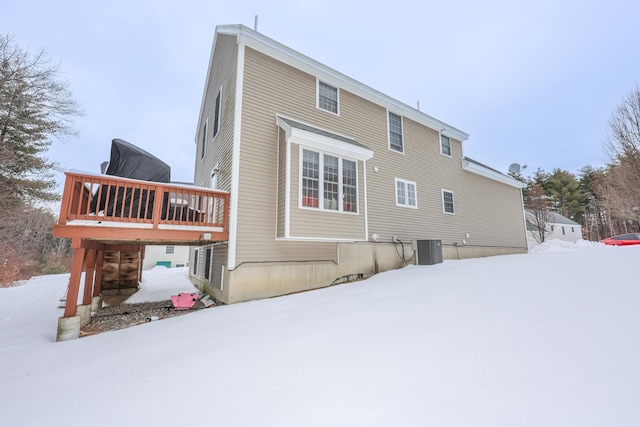 snow covered property featuring central AC and a wooden deck