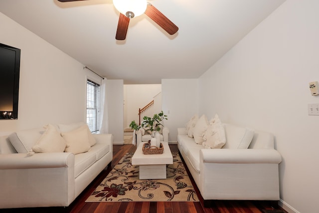 living room with baseboards, ceiling fan, stairway, and wood finished floors