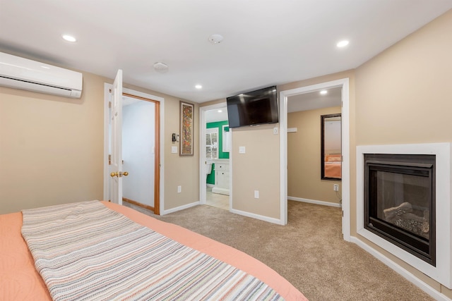 unfurnished bedroom featuring recessed lighting, a wall mounted AC, a glass covered fireplace, light carpet, and baseboards