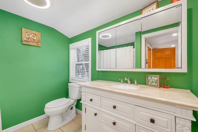 bathroom featuring baseboards, toilet, lofted ceiling, tile patterned floors, and vanity