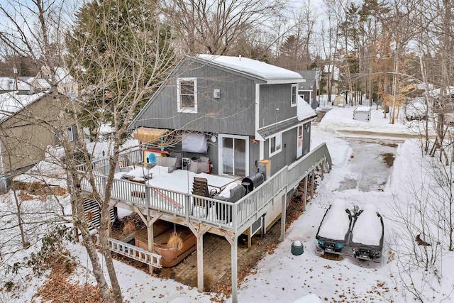 snow covered rear of property with a wooden deck