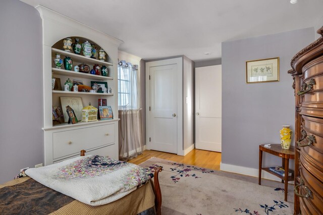 bedroom with light wood-type flooring and baseboards