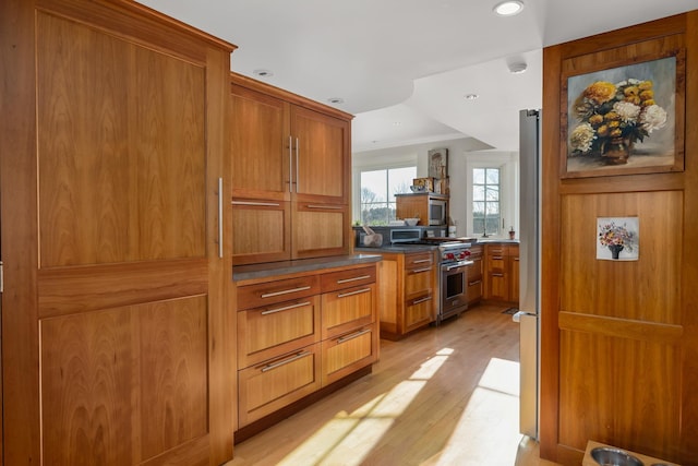 kitchen with ornamental molding, brown cabinets, stainless steel appliances, light wood-type flooring, and recessed lighting