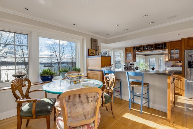 dining space featuring light wood-style floors, ornamental molding, and recessed lighting