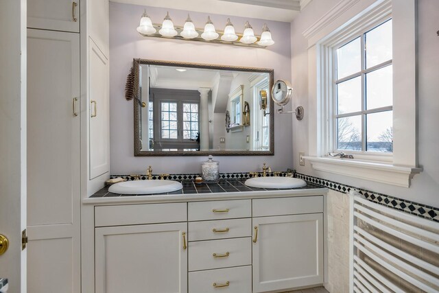 full bathroom featuring plenty of natural light, a sink, and double vanity