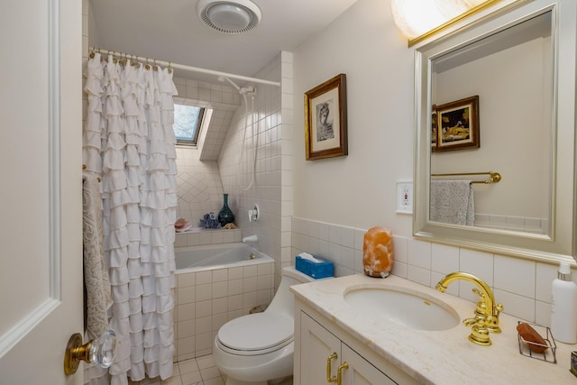 full bathroom featuring a skylight, toilet, tiled shower / bath, vanity, and tile walls