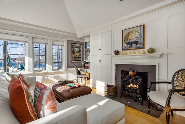 sitting room featuring a fireplace with flush hearth, high vaulted ceiling, and built in shelves