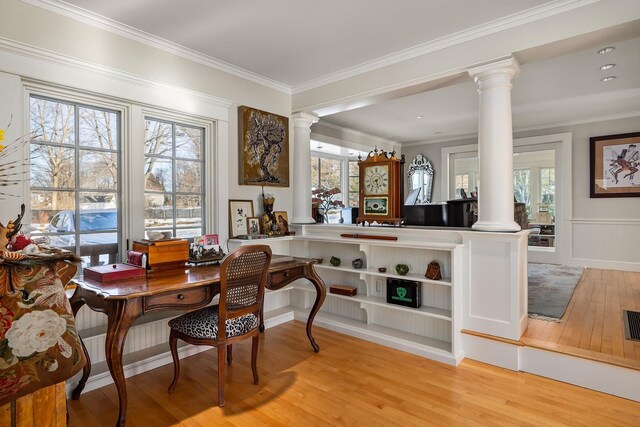 office featuring light wood-style floors, crown molding, and decorative columns