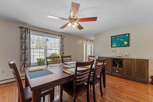 dining space featuring light wood-type flooring, a healthy amount of sunlight, and a ceiling fan