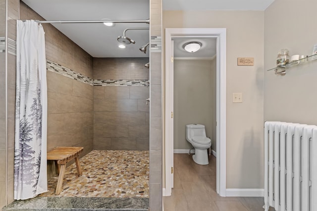 full bath featuring radiator heating unit, a tile shower, toilet, and baseboards