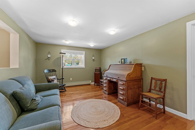 sitting room featuring light wood finished floors, a baseboard radiator, and baseboards