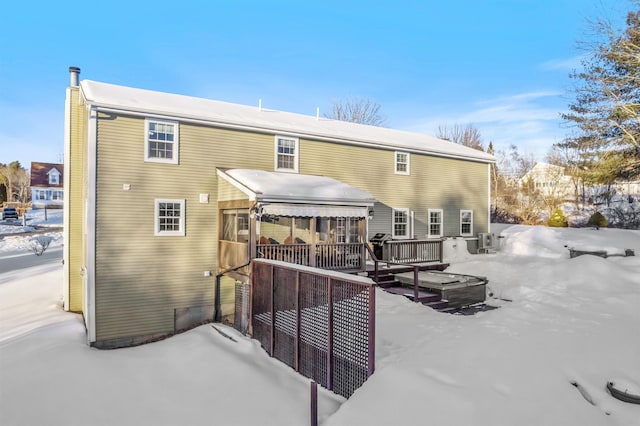 snow covered house with crawl space and a wooden deck