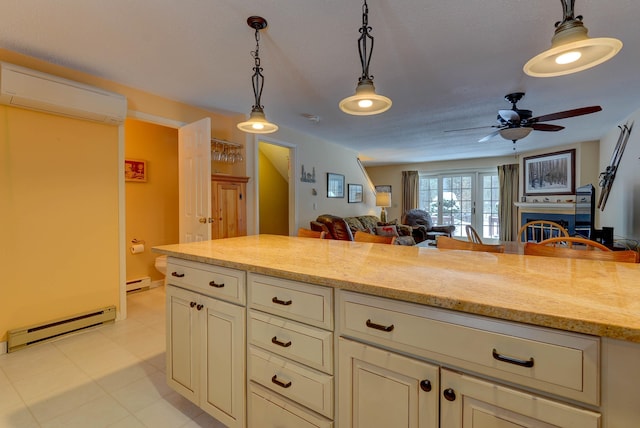 kitchen with a baseboard heating unit, an AC wall unit, a fireplace, and pendant lighting