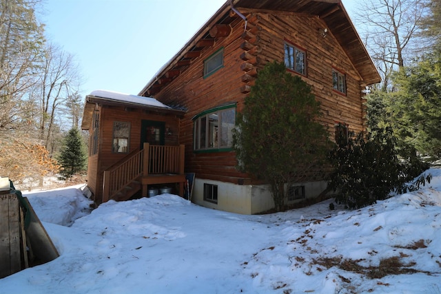 view of snow covered exterior with log exterior