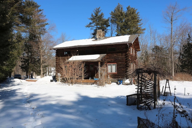 exterior space featuring a chimney and log siding