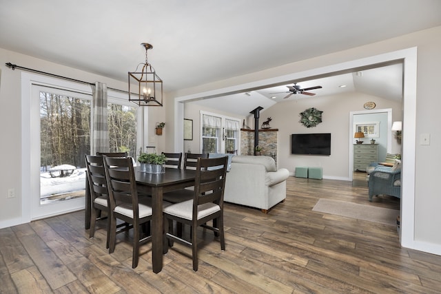 dining area featuring lofted ceiling, dark wood-style floors, baseboards, and ceiling fan with notable chandelier