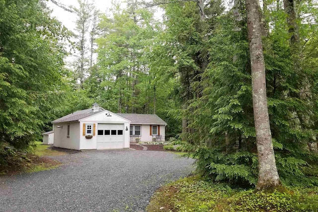 ranch-style home featuring driveway, an attached garage, and stucco siding