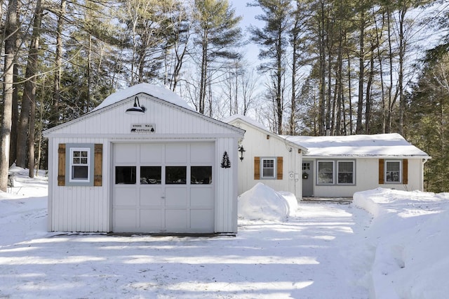 snow covered garage with a detached garage