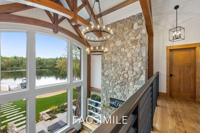 interior space featuring beamed ceiling, wood finished floors, a water view, high vaulted ceiling, and a notable chandelier