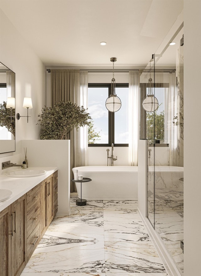 bathroom featuring marble finish floor, a healthy amount of sunlight, a sink, and a freestanding bath