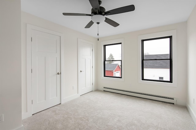 unfurnished bedroom with baseboards, baseboard heating, a ceiling fan, and light colored carpet