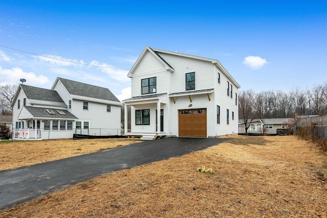 modern farmhouse style home featuring a garage, metal roof, aphalt driveway, and a standing seam roof