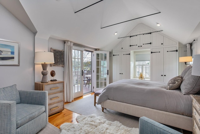 bedroom featuring lofted ceiling, access to exterior, and light wood finished floors