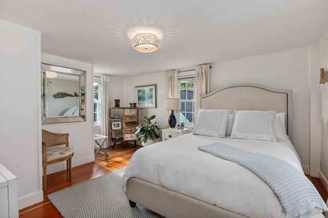 bedroom with wood finished floors and baseboards