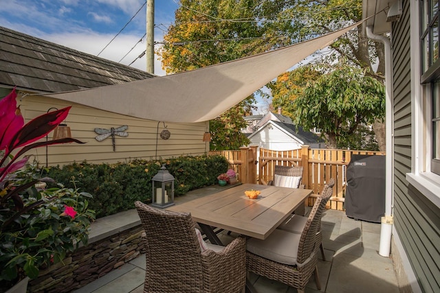 view of patio with outdoor dining space, fence, and grilling area