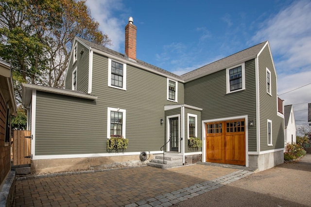 view of front facade with a garage and a chimney