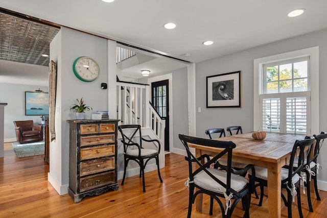 dining area with light wood-style flooring, stairs, baseboards, and recessed lighting