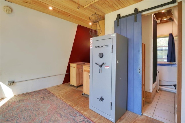 kitchen featuring wooden ceiling, a barn door, and light wood-style floors