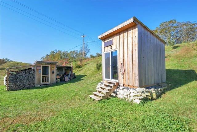 view of outdoor structure with entry steps and an outbuilding