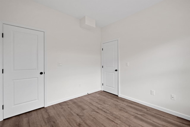 empty room with baseboards and wood finished floors