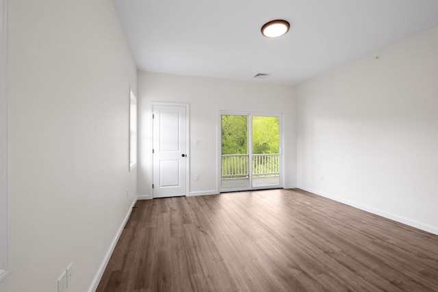 unfurnished room with visible vents, baseboards, and wood finished floors