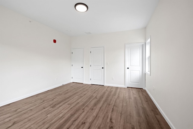 unfurnished bedroom featuring baseboards and wood finished floors