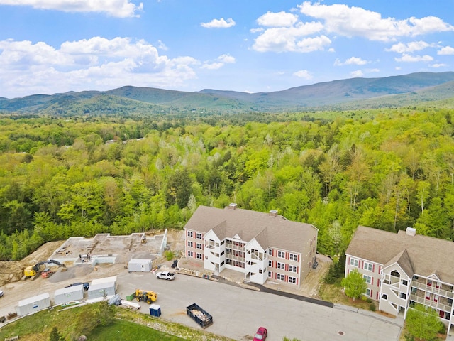 birds eye view of property with a mountain view and a wooded view