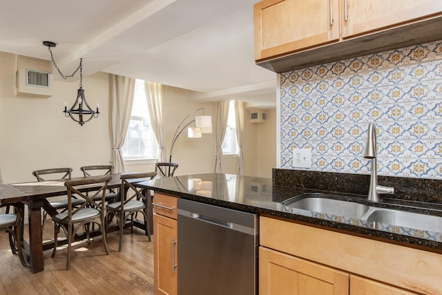 kitchen with dishwasher, dark stone countertops, light wood-type flooring, light brown cabinets, and a sink