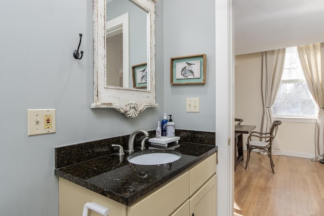 bathroom featuring wood finished floors, vanity, and baseboards