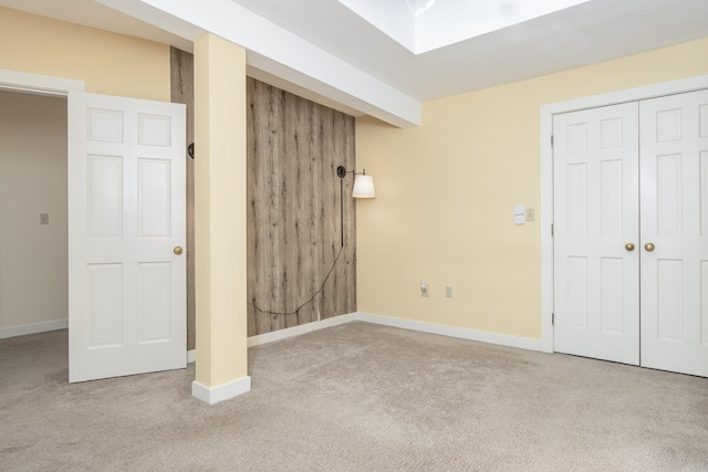 unfurnished bedroom with a closet, carpet flooring, and baseboards