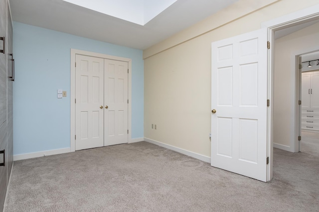 unfurnished bedroom with a closet, carpet flooring, and baseboards