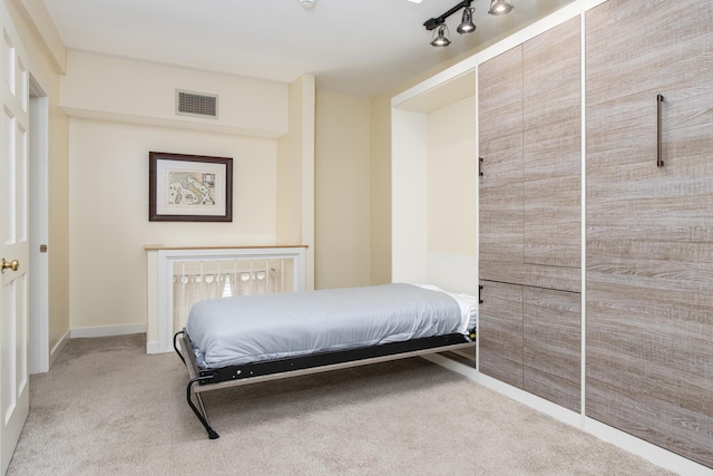 bedroom featuring track lighting, visible vents, and carpet flooring