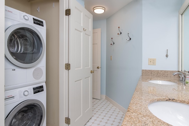 washroom featuring stacked washer / dryer, baseboards, a sink, and light floors